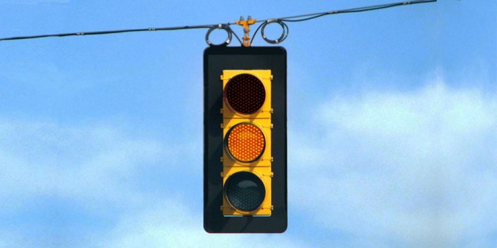 When approaching a steady green traffic light drivers should